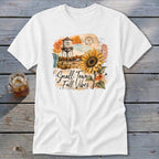 White t-shirt with "Small Town Fall Vibes" text and watercolor artwork of a sunflower and water tower.