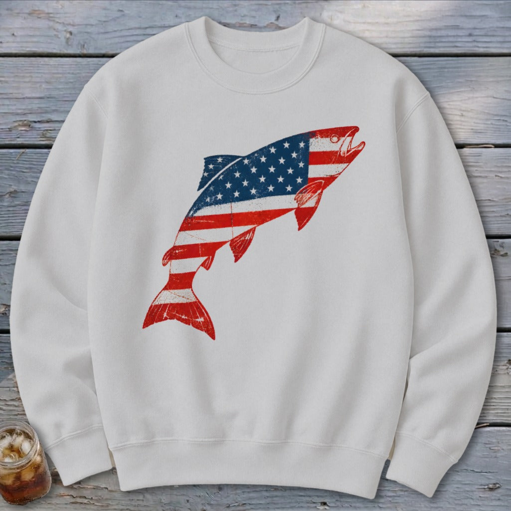 White crewneck sweatshirt featuring a distressed graphic of a jumping fish patterned with the American flag.