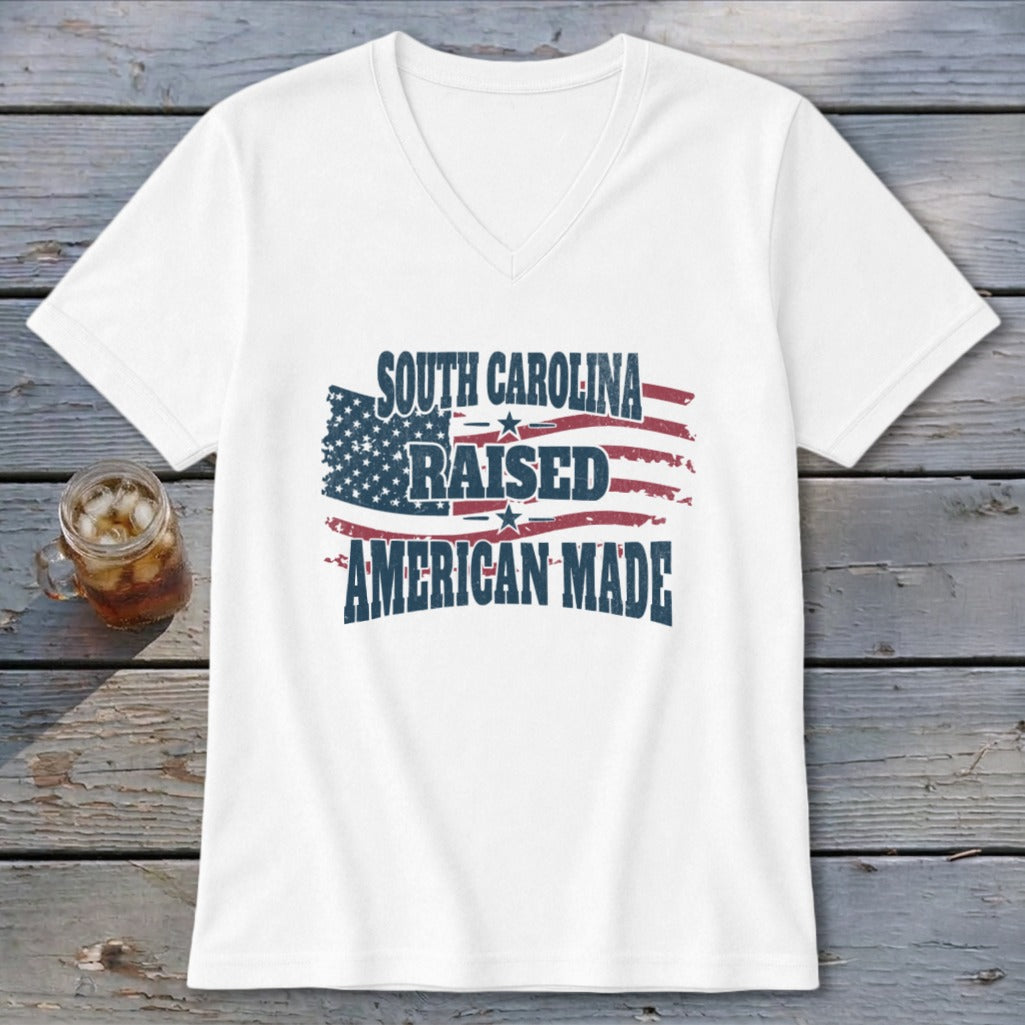 White v-neck t-shirt with "South Carolina Raised American Made" and distressed flag graphic.