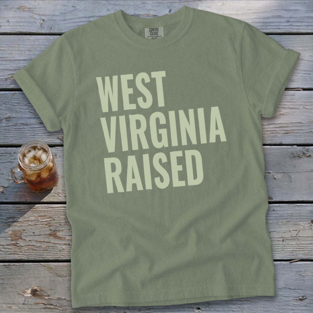 Olive green t-shirt with "WEST VIRGINIA RAISED" text in pale yellow.