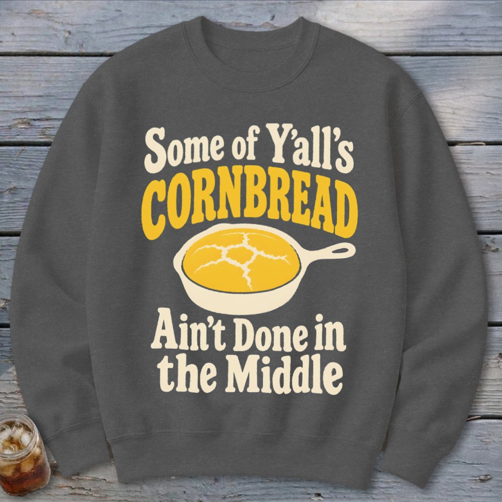 Charcoal gray crewneck sweatshirt featuring the text Some of Y'all's Cornbread Ain't Done in the Middle.