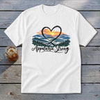 White t-shirt with mountains, sunset, heart, and "Appalachia Strong" text.