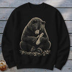 Bear carving wood with a knife on a black sweatshirt.