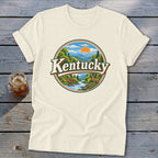 Cream t-shirt with circular Kentucky mountain landscape graphic featuring deer and river.
