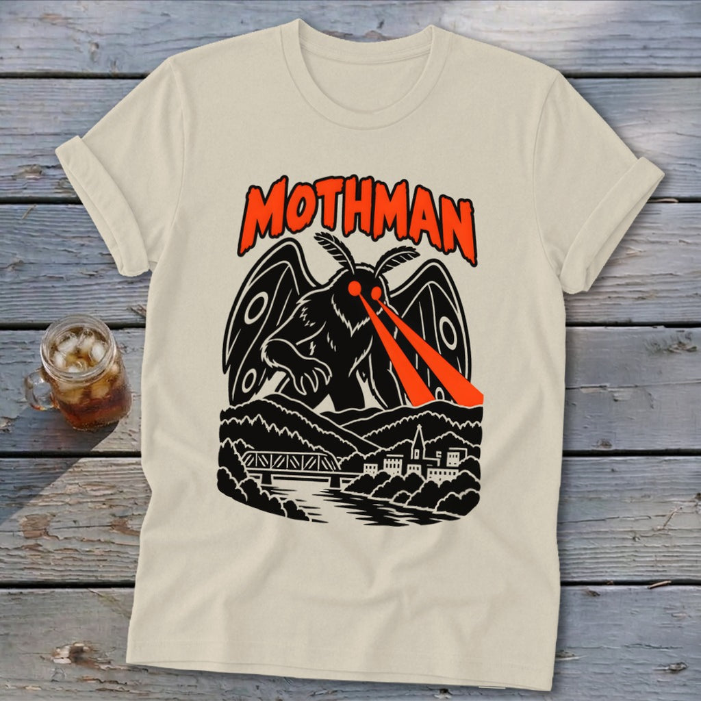 Cream t-shirt featuring a black Mothman graphic with red eyes shooting beams over a town and bridge.
