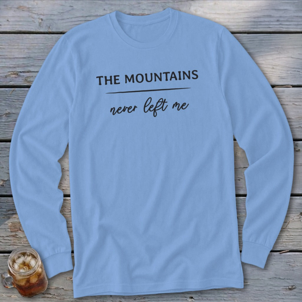 Light blue long-sleeve t-shirt with "THE MOUNTAINS never left me" graphic.