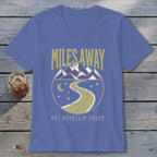 Purple t-shirt with "MILES AWAY BUT MOUNTAIN BOUND" text and mountain road graphic.