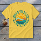 Yellow short-sleeve t-shirt with a round graphic featuring a sunrise over mountains and text.