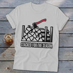 White t-shirt with graphic of axe over stacked firewood and text "STACKED FOR THE SEASON".