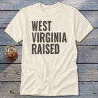 Cream t-shirt with "WEST VIRGINIA RAISED" in dark text.