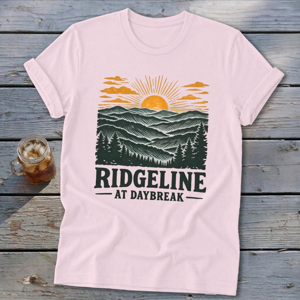 Pink t-shirt with a graphic of a sunrise over mountains, text "RIDGELINE AT DAYBREAK".