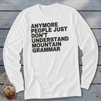 White long-sleeve shirt with black text: "Anymore people just don't understand mountain grammar".