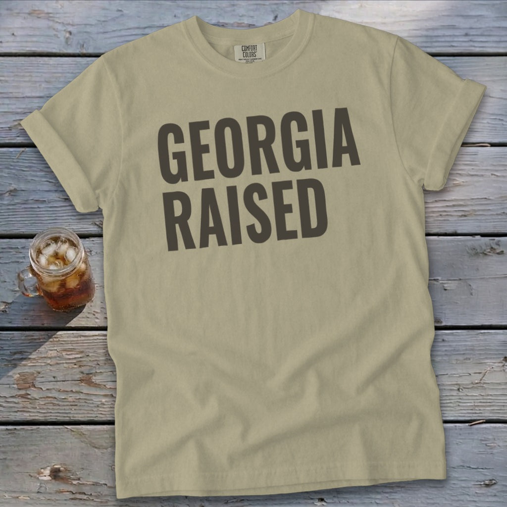 Tan t-shirt with "GEORGIA RAISED" text in dark gray.