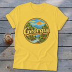 Yellow t-shirt with circular Georgia landscape graphic featuring mountains, river, trees, and a deer.