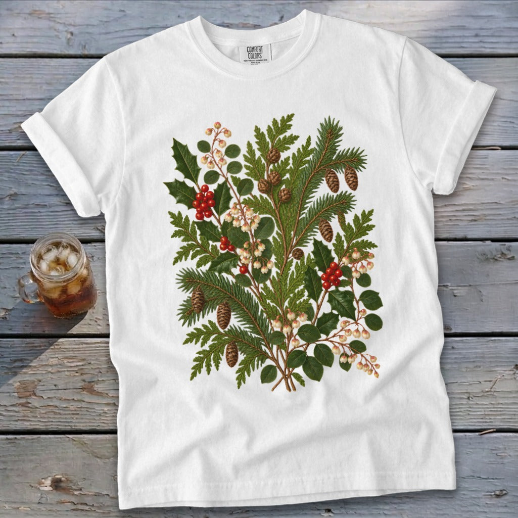 White t-shirt with a botanical print of pine sprigs, holly, and berries.