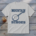 A light gray t-shirt with blue text reading MOUNTAIN ECHOES and a banjo illustration.