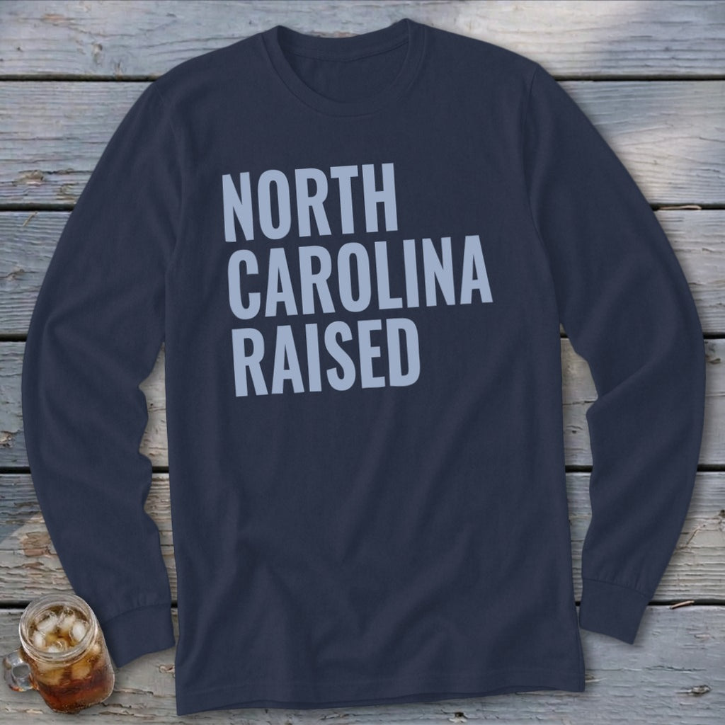 Navy long sleeve shirt with "NORTH CAROLINA RAISED" text in light blue.