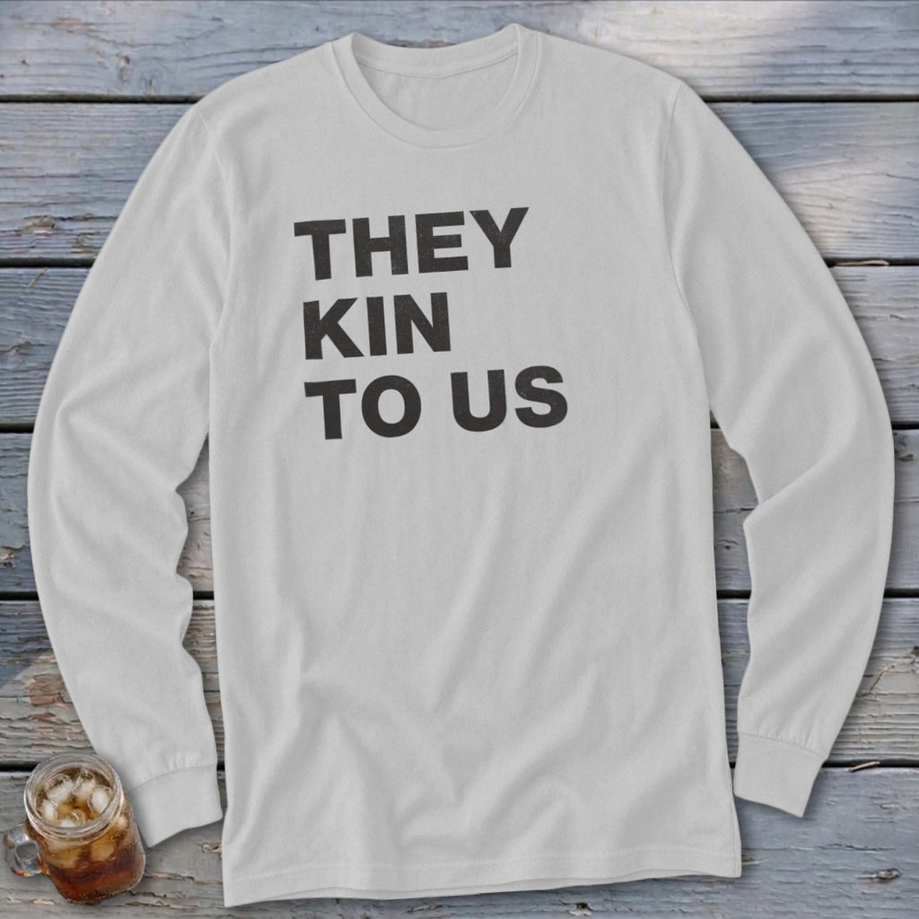 White long-sleeve shirt with black text reading "THEY KIN TO US".