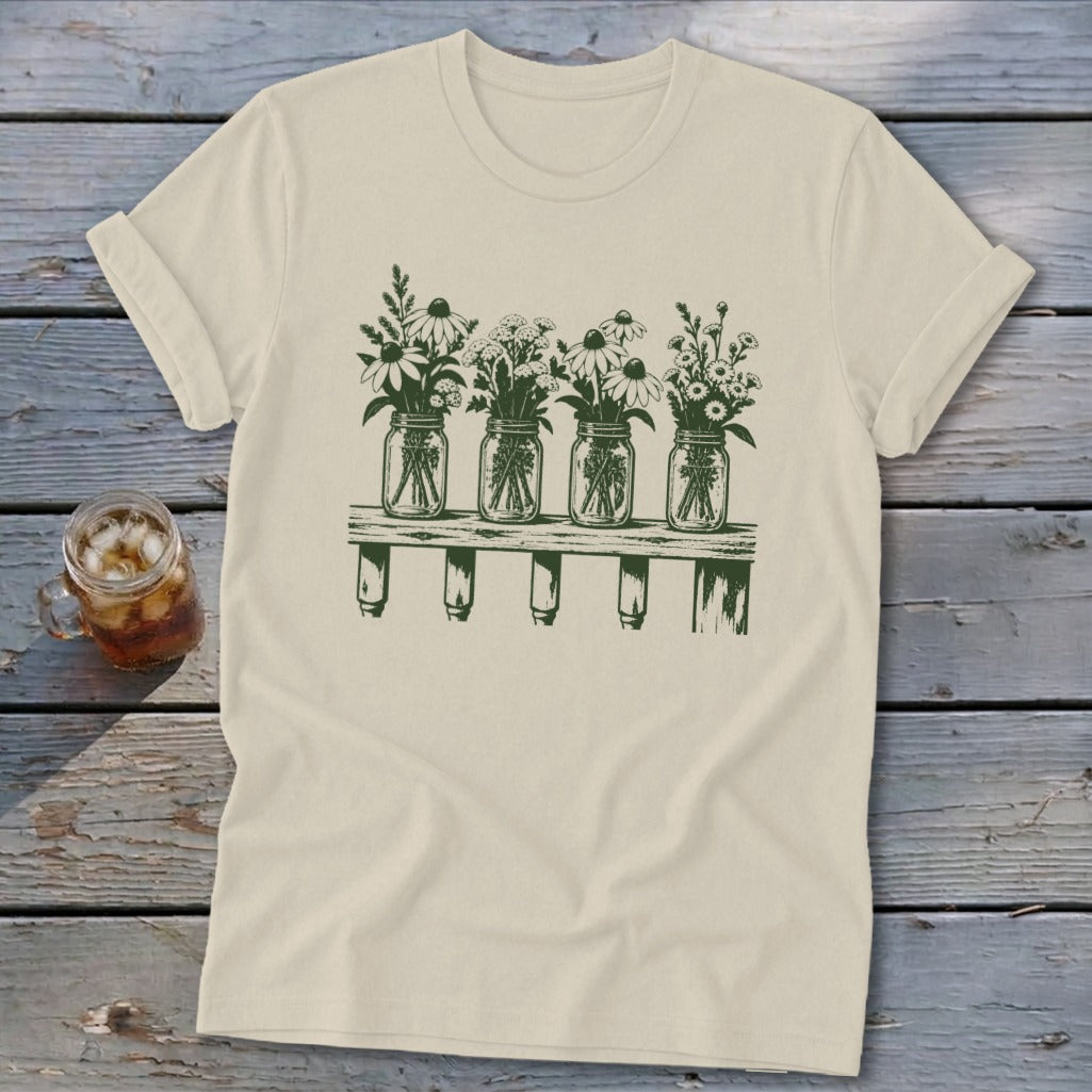 Cream t-shirt with a green graphic of four mason jars filled with wildflowers on a shelf.