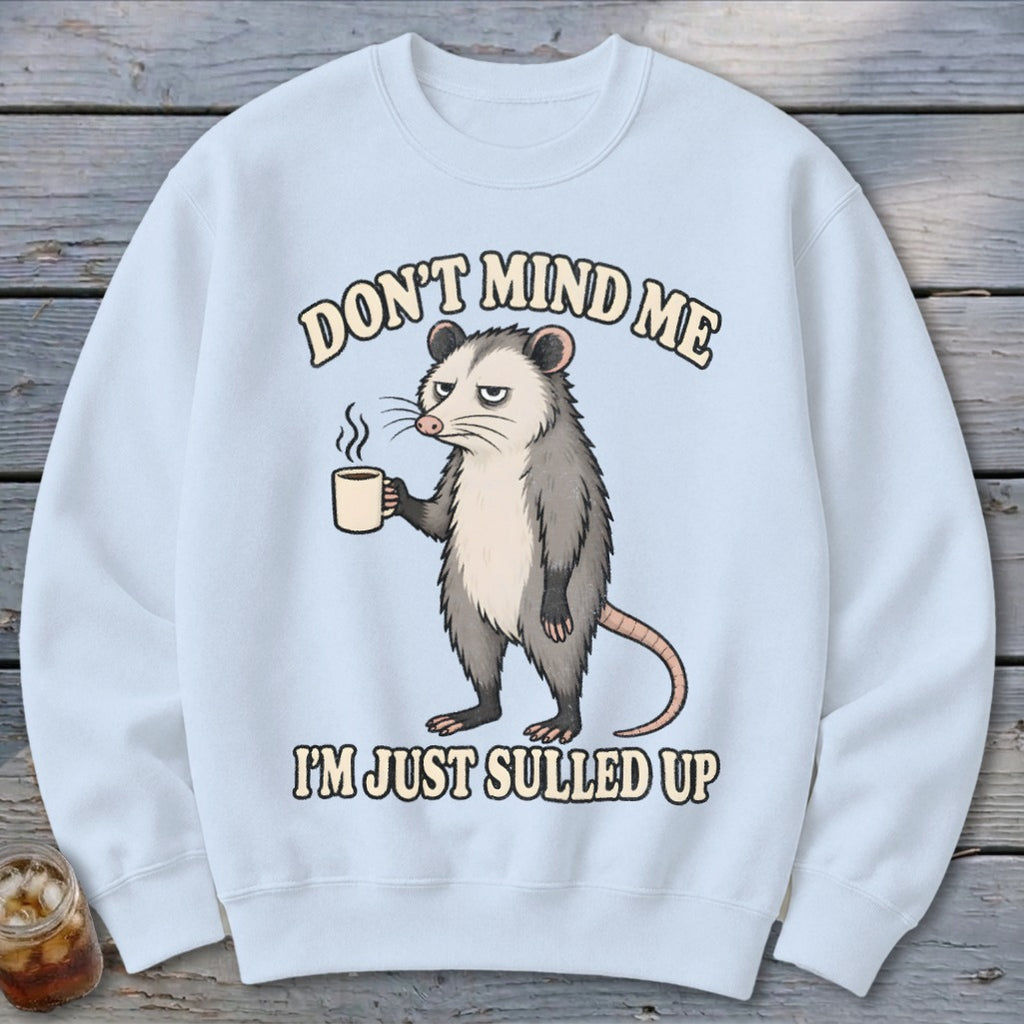Light blue sweatshirt with opossum holding coffee and text "DON'T MIND ME I'M JUST SULLED UP".