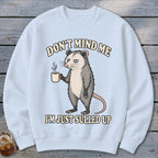 Light blue sweatshirt with opossum holding coffee and text "DON'T MIND ME I'M JUST SULLED UP".