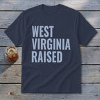 Navy t-shirt with light blue text reading "WEST VIRGINIA RAISED".