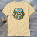 Light yellow t-shirt with a circular graphic of West Virginia mountains, river, and deer.