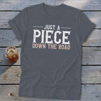 Charcoal t-shirt with "JUST A PIECE DOWN THE ROAD" text.