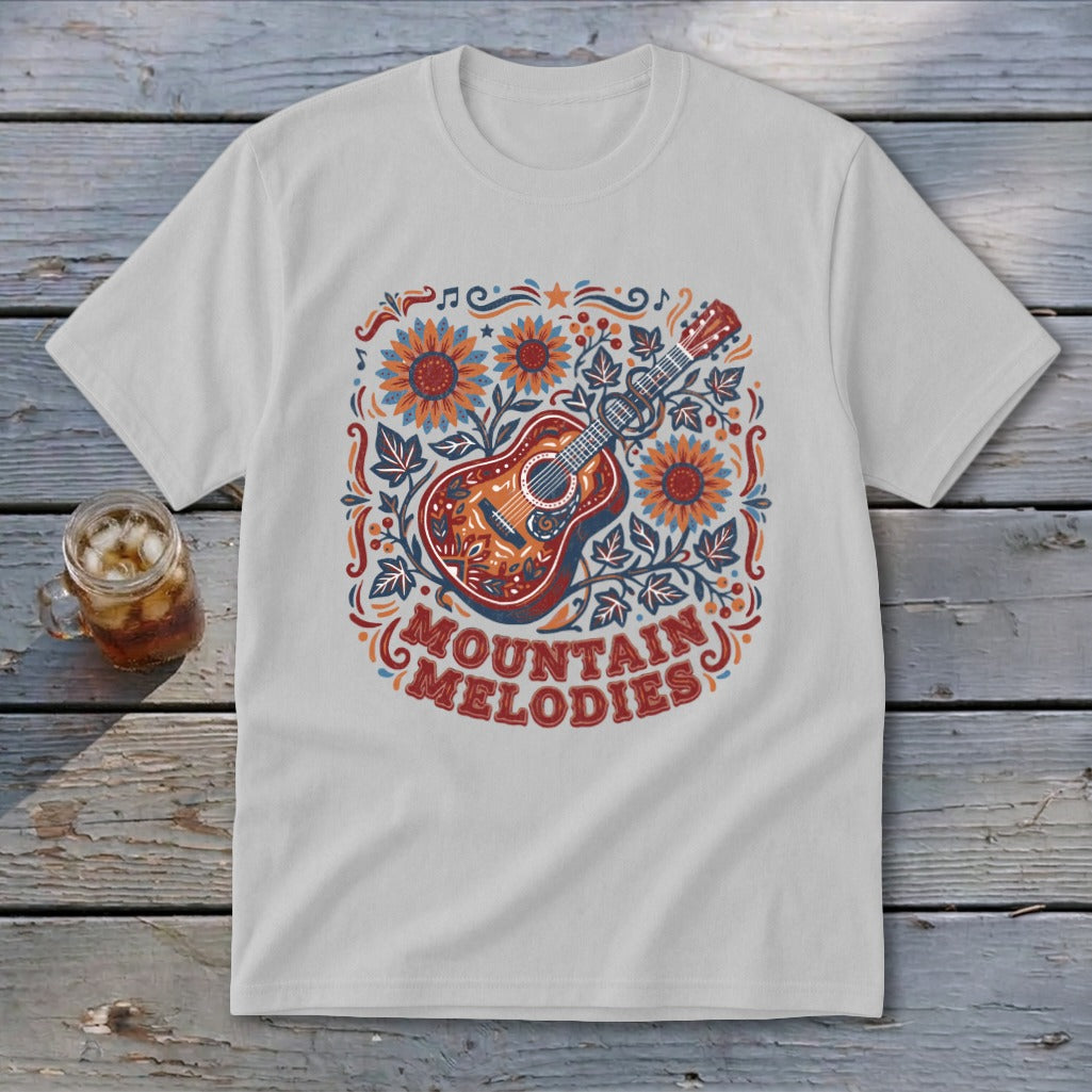 A light gray crewneck t-shirt featuring a folk-art graphic of a guitar, sunflowers, and the text MOUNTAIN MELODIES.