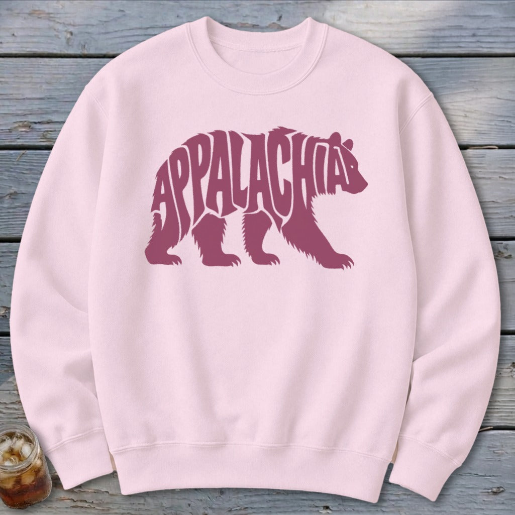A light pink crewneck sweatshirt with a maroon graphic of a walking bear filled with the word Appalachia.