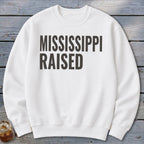 White sweatshirt with black text that reads "MISSISSIPPI RAISED".