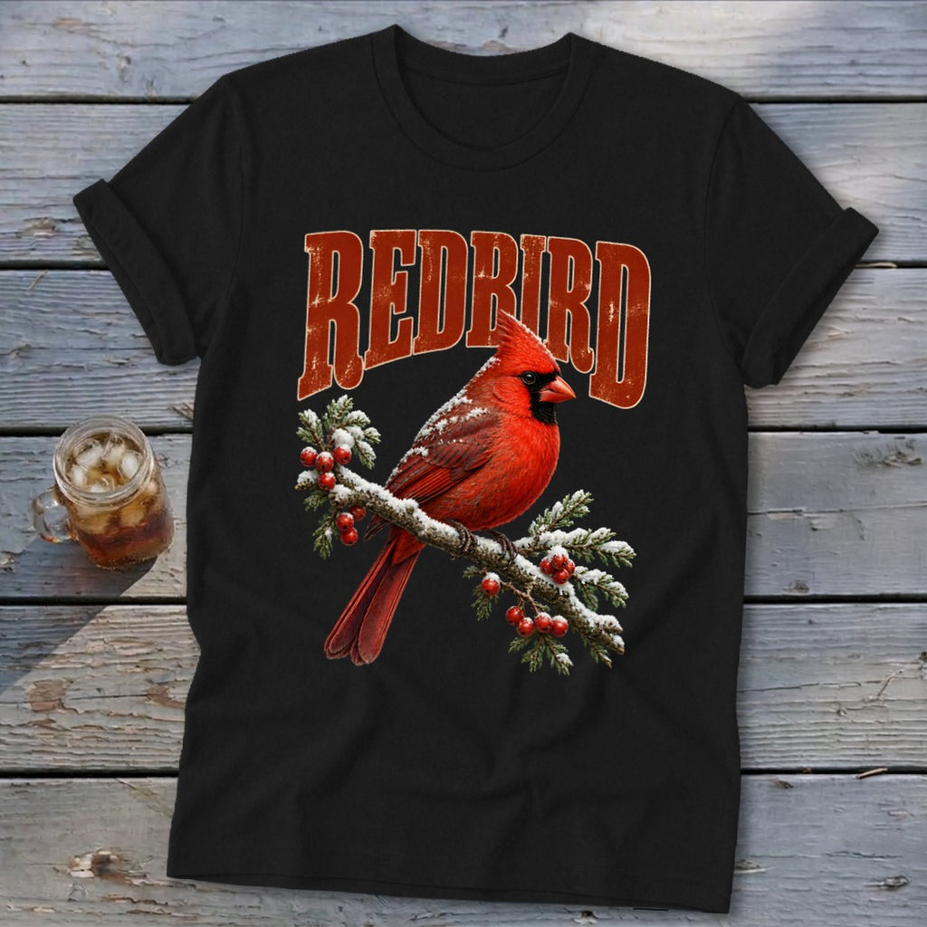 Black t-shirt featuring a red cardinal perched on a snow-covered, berry-laden branch with the text REDBIRD above it.