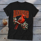 Black t-shirt featuring a red cardinal perched on a snow-covered, berry-laden branch with the text REDBIRD above it.