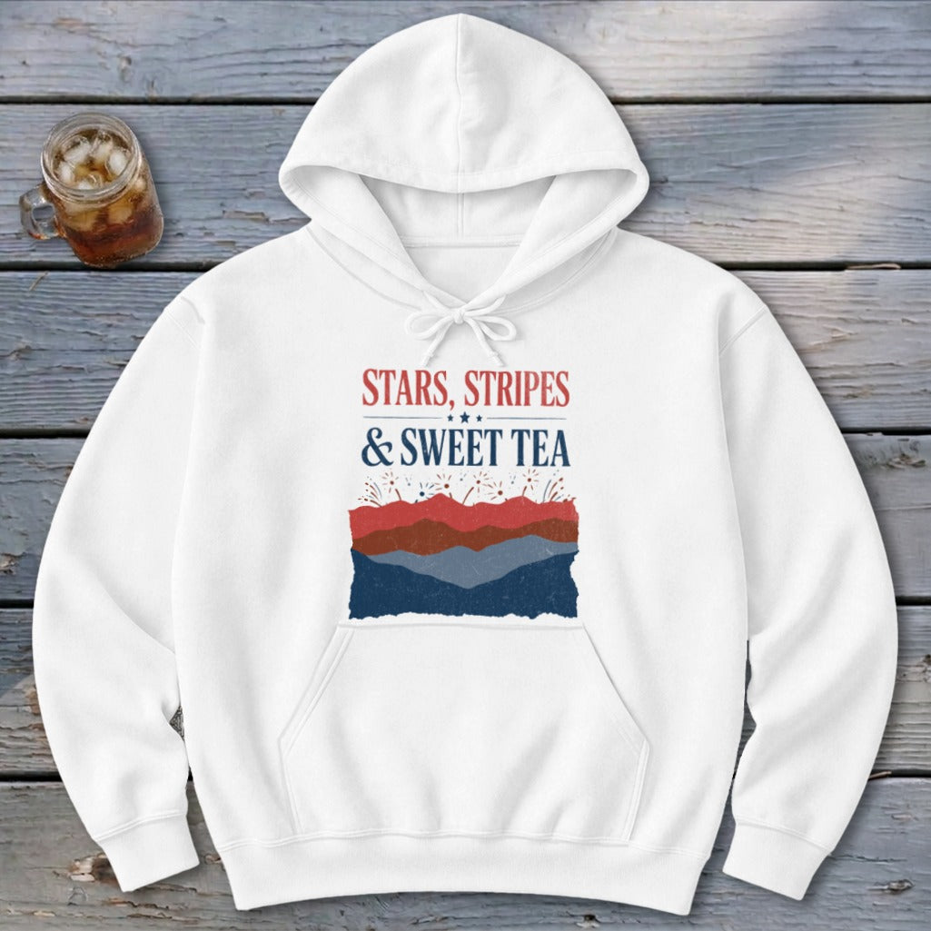 A white hoodie featuring the text Stars, Stripes & Sweet Tea printed on the front above red, white, and blue mountain silhouettes.