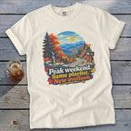 T-shirt with mountain overlook graphic and text "Peak weekend. Same playlist. New overlook."