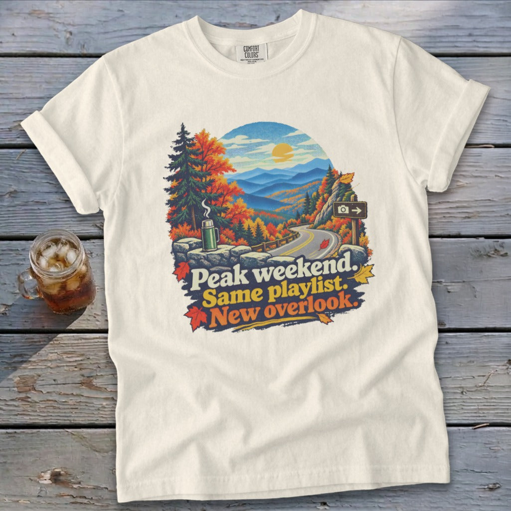 T-shirt with mountain overlook graphic and text "Peak weekend. Same playlist. New overlook."
