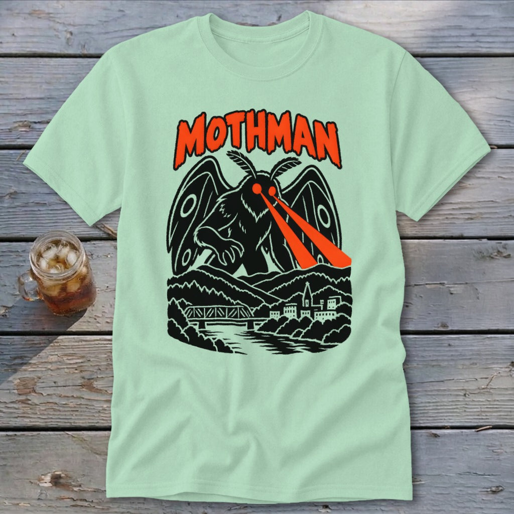 Light green t-shirt featuring a black mothman with red laser eyes over a town and bridge.