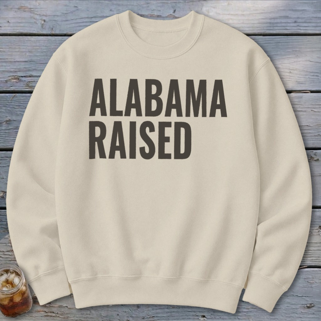 Cream sweatshirt with black text reading "ALABAMA RAISED".