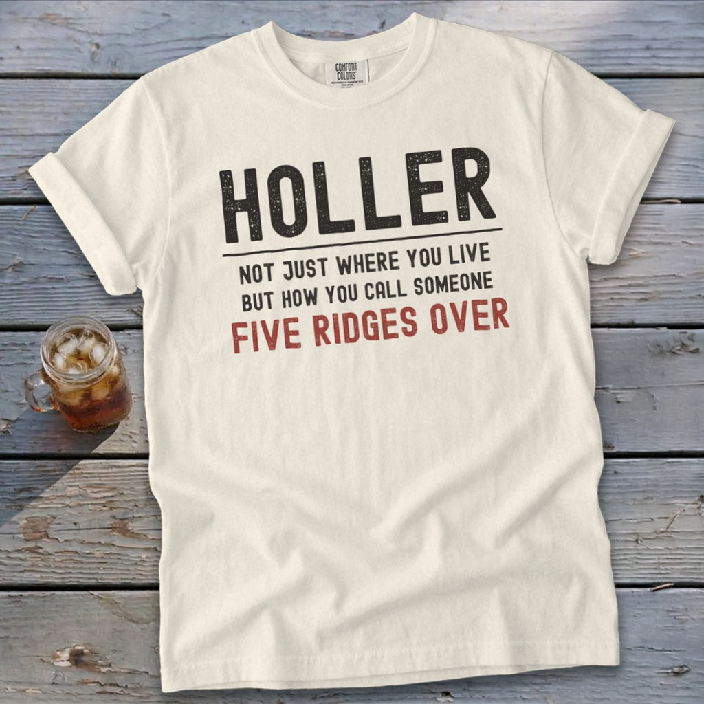 Cream t-shirt with "HOLLER NOT JUST WHERE YOU LIVE BUT HOW YOU CALL SOMEONE FIVE RIDGES OVER" text.