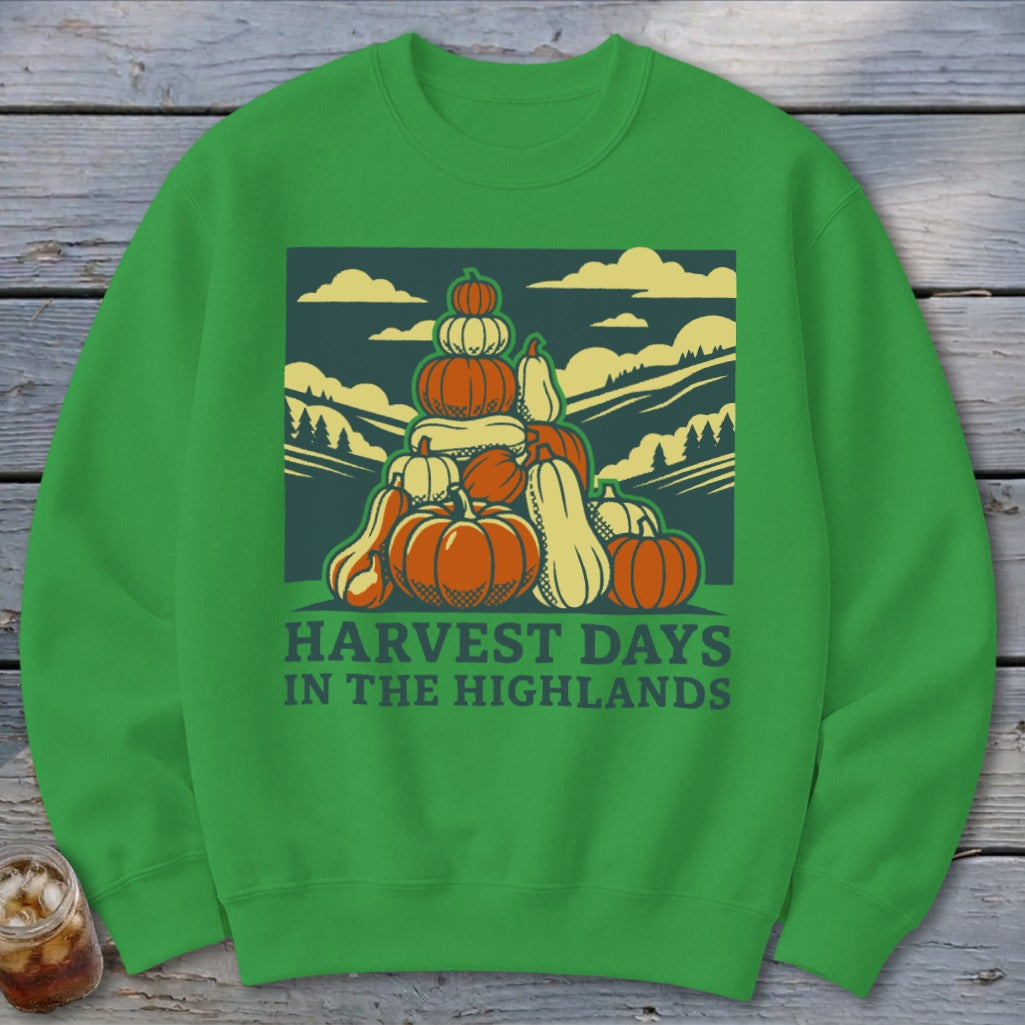 Bright green crewneck sweatshirt featuring a graphic of stacked pumpkins against a landscape with text reading Harvest Days in the Highlands.