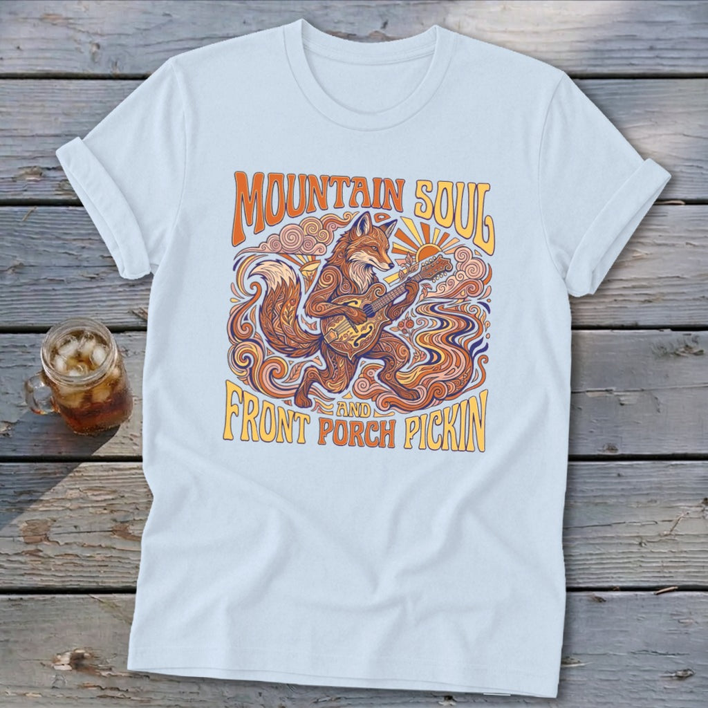 Light blue t-shirt with a graphic of a fox playing a guitar, with text "Mountain Soul and Front Porch Pickin'".