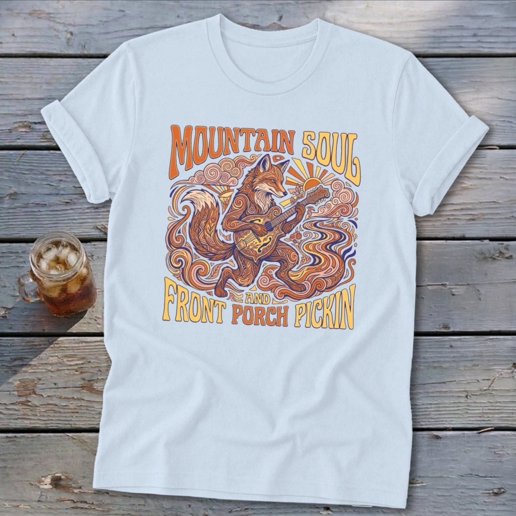 Light blue t-shirt with a graphic of a fox playing a guitar, with text "Mountain Soul and Front Porch Pickin'".
