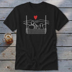 Black t-shirt with white line art of couple and dog on swing under red heart.