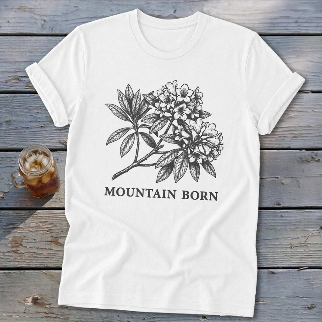 White t-shirt with a black botanical illustration of flowers and leaves, and the text "MOUNTAIN BORN".