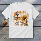 White t-shirt graphic with a sunflower, water tower, and "Small Town Fall Vibes" text.