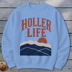 Light blue crewneck sweatshirt featuring the text HOLLER LIFE above a sunset mountain graphic.