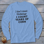 Light blue long-sleeve shirt with "I don't count birthdays I count years of corn" text.