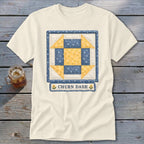 Cream t-shirt with a blue and yellow Churn Dash quilt block design.