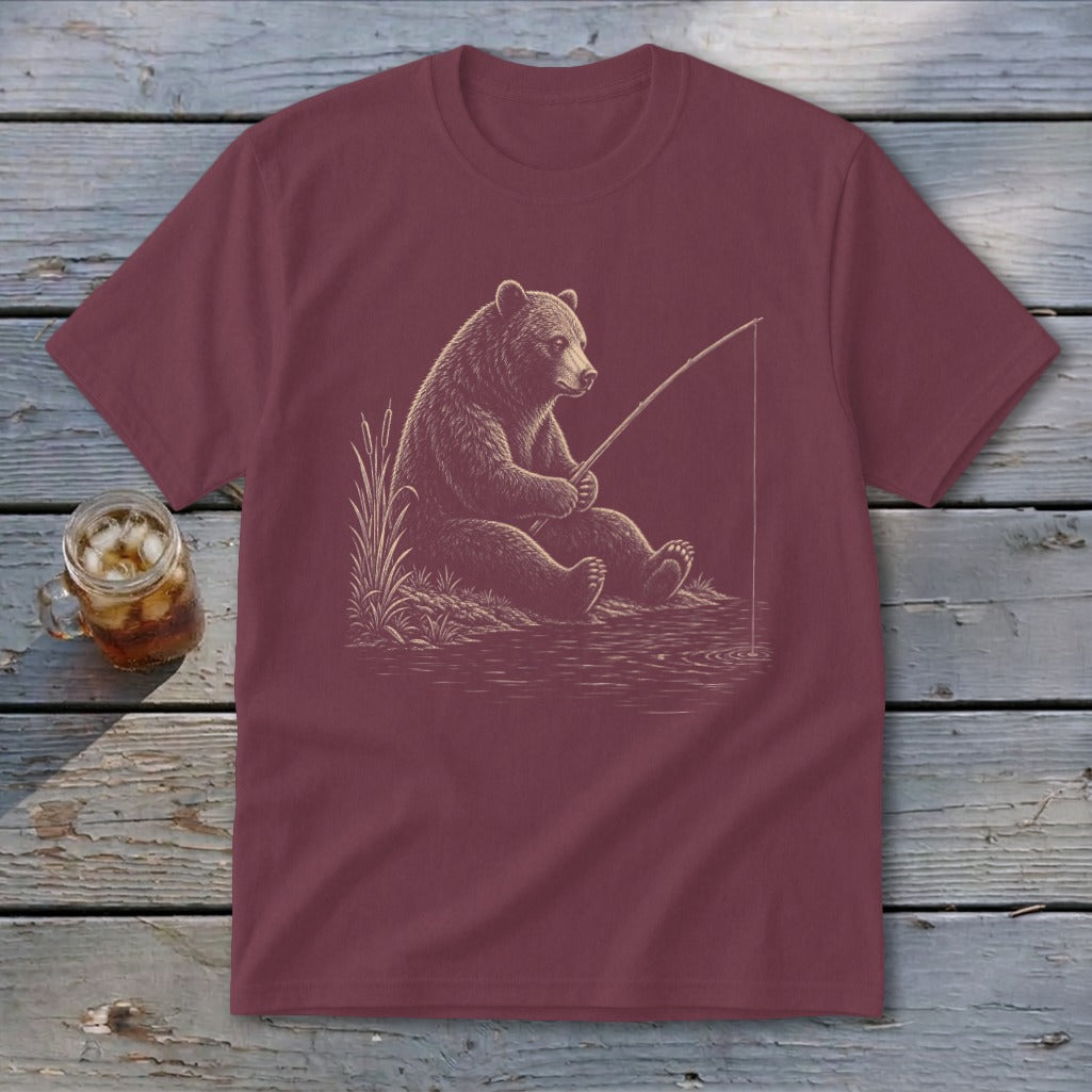 Burgundy t-shirt with a sketch of a bear fishing on a riverbank.