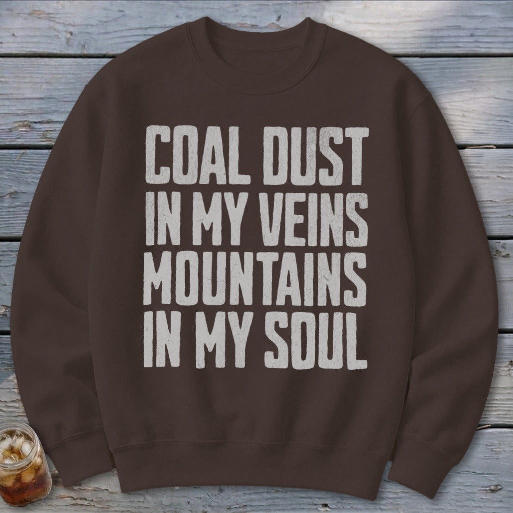 Brown crewneck sweatshirt printed with the white text COAL DUST IN MY VEINS MOUNTAINS IN MY SOUL.